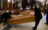 Des employés des pompes-funèbres apportent des cercueils dans l'église de San Giuseppe à Seriate, près de Bergame, le 26 mars 2020