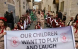 Des scouts palestiniens brandissent des bannières alors qu'ils participent à la procession annuelle de Noël vers l'église de la Nativité dans la ville de Bethléem, en Cisjordanie occupée, le 24 décembre 2024
