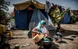 Une femme lave des ustensiles de cuisine dans un camp pour réfugiés à Beledweyne, en Somalie, zone en proie à des inondations, le 14 décembre 2019