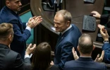 Le chef élu du nouveau gouvernement polonais Donald Tusk (c) applaudi après son discours au Parlement, le 12 décembre 2023 à Varsovie