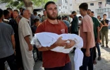 Un Palestinien tient dans ses bras le corps d'un bébé tué dans une frappe israélienne sur une tente de la ville de Gaza, le 30 août 2025, à l'hôpital al-Chifa