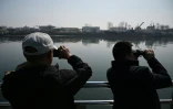 Des touristes observent la ville nord-coréenne de Sinuiju depuis un bateau touristique sur le fleuve Yalu, dans la ville frontalière de Dandong, dans le nord-est de la Chine, le 26 mars 2026