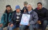 Othman Yahyaoui, entouré de sa famille, présente le 21 jnvier 2016 à Kasserine un portrait de son fils, Ridha Yahyaoui, mort lors d'une manifestation 