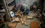 Le potier Yusuf Zakaria Galwani inspecte le 15 août 2020 des moules servant à réaliser des statuettes en terre cuite du dieu hindou Ganesh, dans son atelier du bidonville de Dharavi, à Bombay
