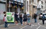 Des clients attendent devant un magasin de fleurs pour acheter du muguet, le 1er mai 2020 Ă Strasbourg