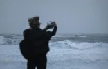 Une personne prend des photos des vagues alors que la tempête Benjamin provoque de fortes rafales de vent à Lacanau, le 23 octobre 2025 en Gironde