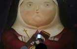 Un visiteur photographie l'une des oeuvres de l'artiste colombien Fernando Botero au centre culturel du palais de La Moneda à Santiago du Chili, le 28 mars 2018