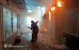 Photo prise et distribuée le 4 avril 2026 par le ministère des situations d'urgence ukrainien montrant un pompier en train d'éteindre un incendie sur un marché après une frappe à Nikopol, dans le centre-est du pays