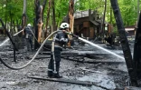 Des pompiers tentent d'éteindre un incendie sur un parc de jeux pour enfants à Kharkiv, dans l'est de Ukraine, après plusieurs frappes russes, le 3 mai 2022