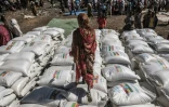 Une femme marche sur des sacs de céréales distribués par le gouvernement éthiopien à Alamata, au Tigré, le 11 décembre 2020.
