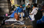 Des migrants transportent leurs effets personnels, lors d'une opération policière sur le boulevard de la Villette à Paris, le 31 octobre 2016