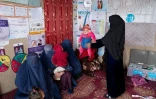 Hasina, volontaire dans le cadre d'un programme de l'Unicef, pèse des enfants our évaluer leur niveau de malnutrition dans un poste de santé du village de Gandanchusma, dans la province de Badakhshan, le 25 février 2024 en Afghanistan