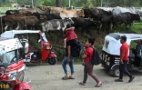 Des migrants arrivant du Nicarague, se dirigent vers des motos-taxis pour se rendre à Trojes, au Honduras, le 11 juin 2022