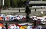 Des corps recouverts de bannières et de drapeaux jonchent le sol le 10 octobre 2015 à Ankara après le pire attentat meurtrier de l'histoire de la Turquie