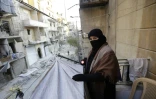 Oum Imad, sur le balcon de l'appartement prêté par un ami, regarde leur ancienne maison totalement détruite lors des combats, le 21 janvier 2017 à Alep, en Syrie