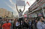 Un jeune libanais brandit une banderole sur laquelle est écrit "Vous brûlez notre avenir", lors d'une manifestation contre le pouvoir à Zouk Mosbeh, au nord de Beyrouth, le 18 octobre 2019
