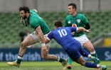 Le demi d'ouverture français Matthieu Jalibert (c) plaque le centre irlandais Robbie Henshaw lors du match du Tournoi des six Nations, à Dublin, le 14 février 2021