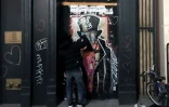 Le graffeur Saynosleep peint la devanture d'un commerce à Soho, le 15 décembre 2020 à New York