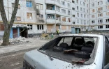 Une voiture et un immmeuble endommagés après un bombardement à Kharkiv, le 14 avril 2022