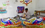 L’artiste Haider Ali peint une paire de baskets dans son studio de Karachi, le 28 février 2022