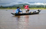 Le pêcheur Chaweng Yothaud (d) prélève des échantillons pour tester un empoisonnement à l'arsenic le long de la rivière Kok dans la région du Triangle d'or, dans la province de Chiang Rai, dans le nord de la Thaïlande, le 25 mai 2025