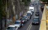 Des habitants de Caracas poussent leur voiture le 23 mars 2020 avant de pouvoir faire le plein dans une station-service