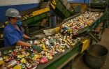 Un employé vérifie les canettes usagées pour le recyclage dans un hangar de l'entreprise Latasa Garimpeiro Urbano, le 26 juin 2023 à Sao Paulo, au Brésil