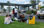 Des voyageurs attendent près de leurs bagages à l'extérieur de l'aéroport Ben Gourion d'Israël, le 4 mai 2025