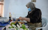 Une femme prépare des plats dans la cuisine de l'entreprise "Le Goût de Mossoul", le 13 septembre 2023 à Mossoul, en Irak