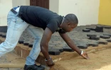 Un Camerounais pave le sol avec des pavés fabriqués avec des déchets plastiques recyclés, le 1er février 2016 à Yaoundé 
