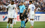 Le capitaine des Bleus Presnel Kimpembé échange avec l'arbitre israélien Orel Grinfeld à propos d'un penalty siflé pour la Croatie au Stade de France, le 13 juin 2022  