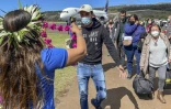 Les premiers touristes à atterrir sur l'île de Pâques depuis plus de deux ans sont accueillis avec un collier de fleurs, à l'aéroport de international de Mataveri, à Hanga Roa, au Chili, le 4 août 2022