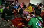 Des proches d'élèves disparus attendent des nouvelles pendant les recherche de victimes à l'école islamique Al Khoziny à Sidoarjo, dans la province de Java oriental, après l'effondrement d'un bâtiment pendant les prières, le 5 octobre 2025 en Indonésie