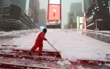 Une personne dégage la neige à Times Square, à New York, en pleine tempête le 23 février 2026