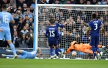 Le milieu de terrain belge Kevin De Bruyne ouvre le score pour Manchester City face Ă son compatriote et gardien du Real Madrid Thibaut Courtois, lors de leur demi-finale aller de la Ligue des Champions, le 26 avril 2022 Ă l'Etihad Stadium