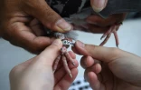 Un code d'identification est attaché au pied d'un pigeon voyageur lors d'une course aux Philippines, le 28 mars 2019