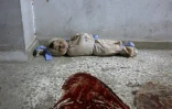 Le corps d'un enfant syrien enveloppé dans une couverture et placé à même le sol dans une clinique de fortune dans la localité de Douma, dans le fief rebelle de la Ghouta orientale, cible de bombardements intensifs du régime, le 22 février 2018