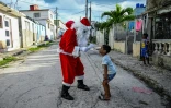 Un enfant donne sa lettre au ère Noël dans une rue de La Havane, le 21 décembre 2023 à Cuba