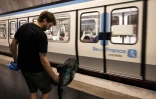 Une personne prend le métro avec un ventilateur, à Paris, le 10 juillet 2026