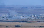 Photo prise le 15 octobre 2019 depuis le côté turc de la frontière à Ceylanpinar montrant de la fumée s'élevant de la ville syrienne de Ras al-Aïn