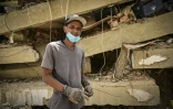 Raul Alvarado (g) cherche des proches disparus sous les décombres de l'immeuble OPP 26 de 16 étages ç Carabellada, dans l'Etat de La Guaira, le 6 juillet 2026 au Venezuela