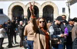 L'avocate Dalila Mssadek (c), soeur du juriste Jawhar Ben Mbarek (c) et membre du comité de défense des détenus accusés de "complot contre la sécurité de l'Etat", fait le signe de la victoire devant le palais de justice de Tunis, lors de la reprise du procès de dizaines d'opposants tunisiens, le 11 avril 2025
