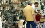 Des touristes dans une boutique de souvenirs du quartier historique de Plaka à Athènes le 05 août 2004