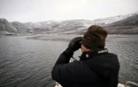 Un chasseur à bord de son bateau, recherche des phoques dans un fjord près de Sisimiut, au Groenland, le 1er février 2026