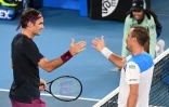 Le Suisse Roger Feder (g) serre la main de l'Américain Steve Johnson après l'avoir battu au 1er tour de l'Open d'Australie, le 20 janvier 2020 à Melbourne