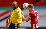 L'attaquant d'Arsenal Alexandre Lacazette (g) à la lutte avec le défenseur de Sheffield Jack Robinson, le 28 juin 2020 à Sheffield