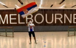Un supporter brandit un drapeau de la Serbie à l'aéroport de Melbourne, où Novak Djokovic est resté bloqué, le 6 janvier 2022