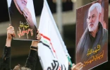 Un Irakien tient les portraits du puissant général Qassem Soleimani et d'un chef de la milice irakienne Hachd al-Chaabi, tués par une frappe américaine, pendant leurs obsèques à Bagdad, le 4 janvier 2020