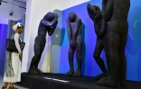 Une visiteuse du musée des civilisations à Abidjan s'arrête devant plusieurs statues, le 29 septembre 2017