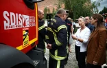 La Première ministre française Elisabeth Borne (2eD) s'entretient avec un pompier après l'incendie d'une maison de vacances pour personnes handicapées à Wintzenheim, dans l'est de la France, le 9 août 2023
